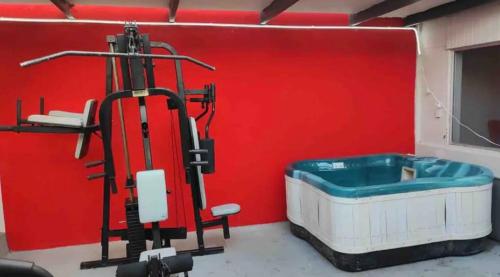 a bath tub in a room with a red wall at Cabaña DW in Tijuana