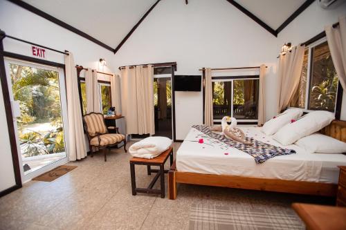 a bedroom with a bed in a room with windows at Falling Leaves Lodge in San Ignacio