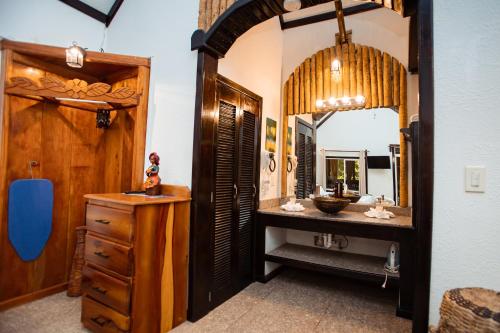 een badkamer met een wastafel en een spiegel bij Falling Leaves Lodge in San Ignacio