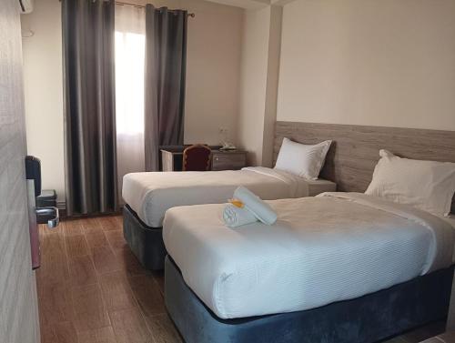 a hotel room with two beds and a window at Nour Echames Hotel - Chéraga in Cheraga