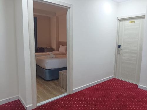 a room with a bedroom with a bed and a doorway at Nour Echames Hotel - Chéraga in Cheraga