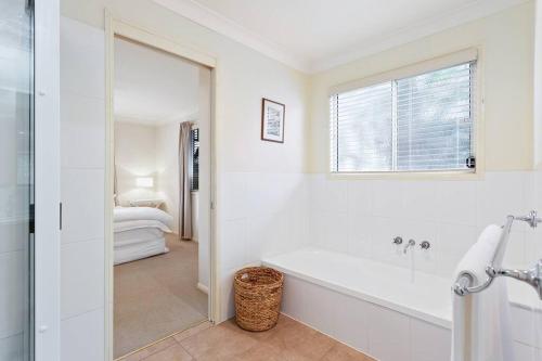 un bagno bianco con vasca e una camera da letto di Cottage on Kent a Toowoomba