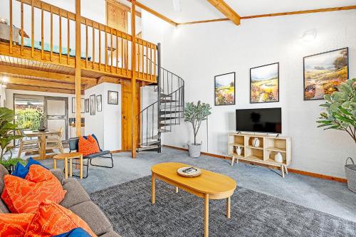 a living room with a couch and a tv at 8 Cottesloe Steps to beach - sleeps 3 in Perth