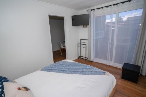 a bedroom with a bed and a large window at Departamentos BP in Puerto Varas