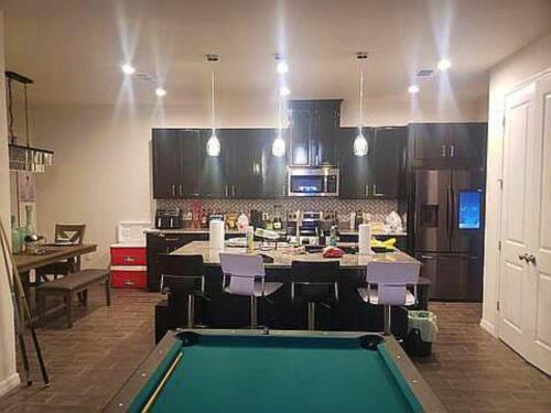 ein Wohnzimmer mit einem Billardtisch und eine Küche in der Unterkunft Troy@Kissimme in Kissimmee