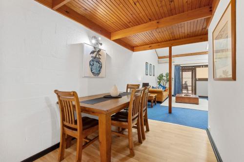 a dining room with a wooden table and chairs at 21 Cottesloe Steps to beach - sleeps 3 in Perth
