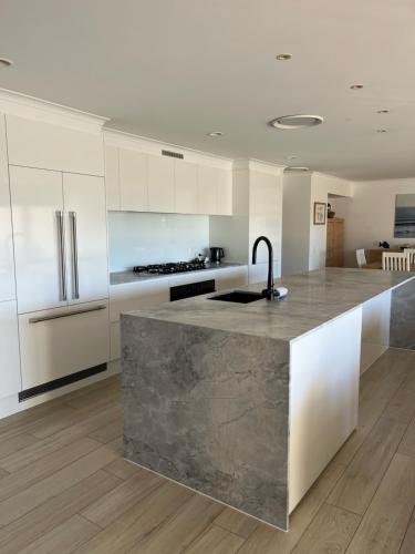 a kitchen with a marble counter top in a room at The Village Holiday Apartments at Burleigh Heads in Gold Coast