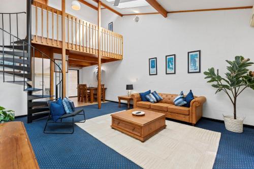 a living room with a couch and a table at 21 Cottesloe Steps to beach - sleeps 3 in Perth