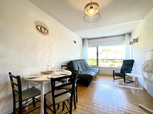 un salon avec une table et un canapé dans l'établissement Studio cabine avec vue mer, 30m de la plage, parking. Wi-Fi et linge en option. - FR-1-338-542, à Sète