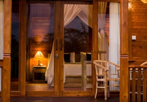 a wooden room with a bed with a window at Mathura Ubud in Ubud