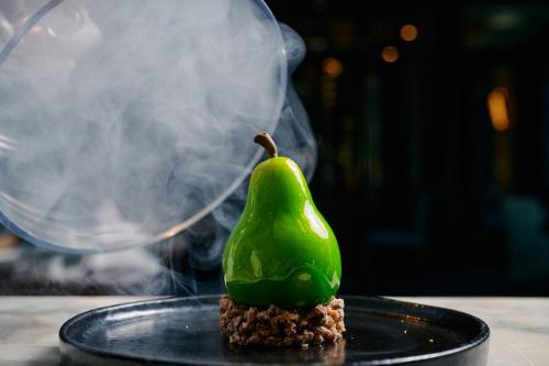 a green pear sitting on top of a black plate at The Westin Melbourne in Melbourne