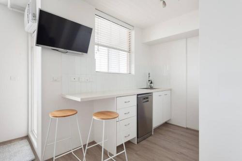 a kitchen with a counter and two stools in it at Bondi Beach Studio City Views and Balcony in Sydney
