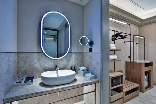 a bathroom with a sink and a mirror at Mercure Hangzhou Xixi Zijingang in Hangzhou