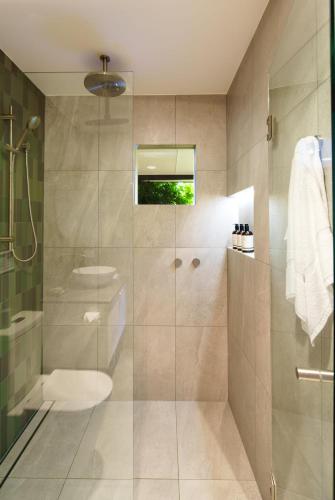 a bathroom with a shower with a glass door at Grove Hinterland Retreat - 15 mins to beach in Kiels Mountain