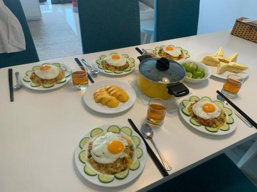 een tafel met borden ontbijt erop bij Diamond Beach Villa Da Nang in Da Nang