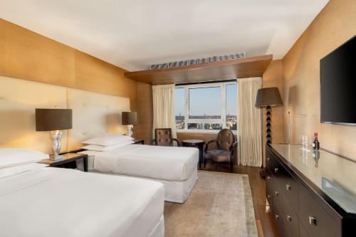 a hotel room with two beds and a television at Sheraton Lisboa Hotel & Spa in Lisbon