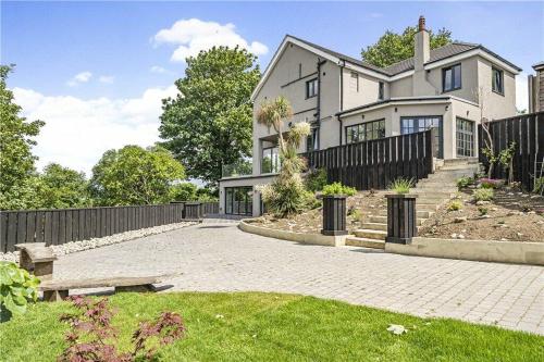 a large white house with a wooden fence at The Ridge London - Luxury Designer Villa with hot tub and sauna, Bexley borough of London in London