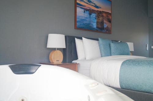 a bedroom with two beds and a table with a lamp at Waves Luxury Suites in Port Campbell