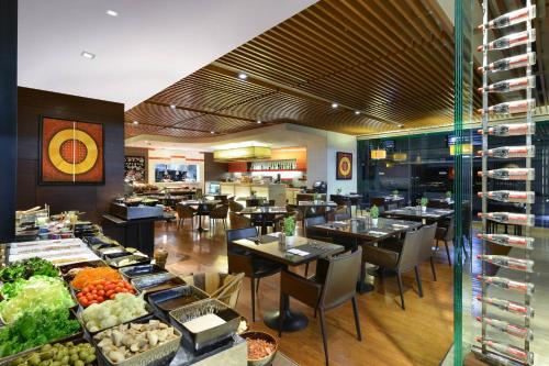 a restaurant with tables and chairs and a buffet at Sathorn Vista, Bangkok - Marriott Executive Apartments in Bangkok
