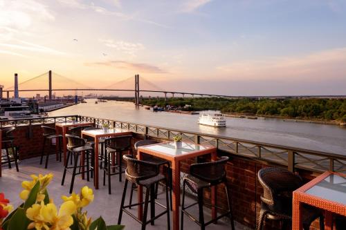 a restaurant with a view of a river and a bridge at The Bohemian Hotel Savannah Riverfront, Autograph Collection in Savannah