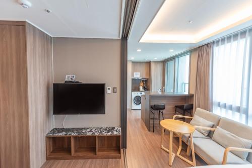 a living room with a couch and a tv at Elmomento Haeundae in Busan