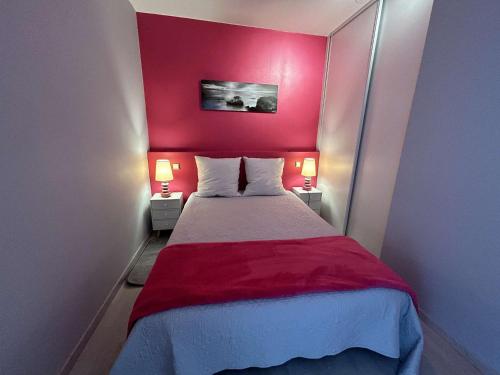 - une chambre dotée d'un mur rouge et d'un lit avec deux lampes dans l'établissement Appartement Studio cabine, 4 couchages, face à la mer - FR-1-224C-304, à Saint-Jean-de-Monts
