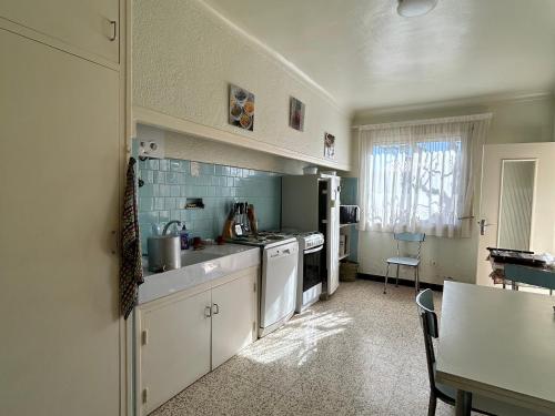 une cuisine avec un évier et une cuisinière four supérieur dans l'établissement Maison Familiale à Saint-Cyprien, Proche Plage et Commerces - FR-1-732-75, à Saint-Cyprien