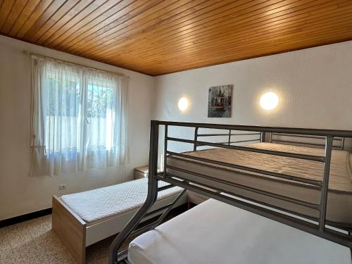 une chambre avec deux lits superposés et une fenêtre dans l'établissement Maison Familiale à Saint-Cyprien, Proche Plage et Commerces - FR-1-732-75, à Saint-Cyprien