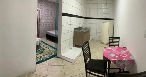 a room with a table and chairs and a bathroom at AP próximo ao aeroporto, praia, porto e Beto carrero in Navegantes