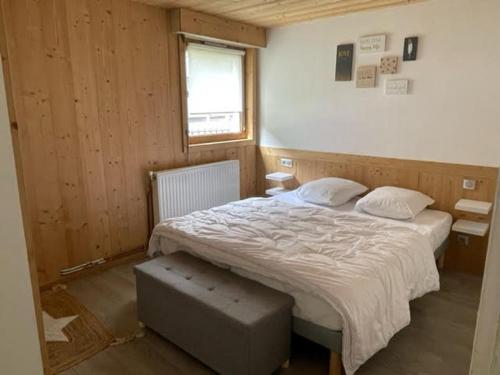 une chambre avec un grand lit avec une fenêtre dans l'établissement Charmant appartement rénové, 4 pers, balcon sud, prox. pistes et navette, Le Grand-Bornand - FR-1-467-126, au Grand-Bornand