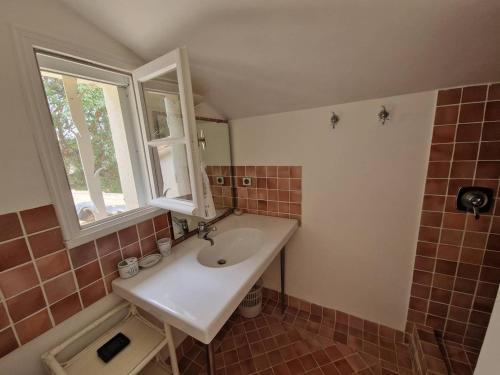 une petite salle de bain avec un lavabo et une fenêtre dans l'établissement Villa 4 chambres avec piscine privée et climatisation - FR-1-100-339, à Cavalaire-sur-Mer