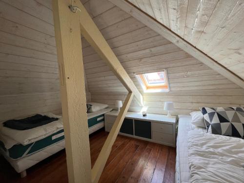 Cette chambre mansardée comprend un lit et un bureau. dans l'établissement Appartement T3 Lumineux - Parking Privé - Proche Centre et Plages d'Arcachon - FR-1-319-567, à Arcachon