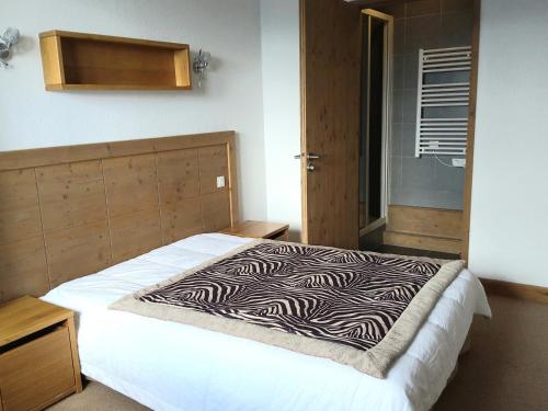 un lit dans une chambre avec une couverture zébrée dessus dans l'établissement Appartement avec balcon, piscine, sauna et parking - 8 personnes, Arc 1600 - FR-1-411-941, à Bourg-Saint-Maurice