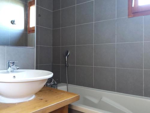 une salle de bain avec un lavabo et une baignoire dans l'établissement Appartement avec balcon, piscine, sauna et parking - 8 personnes, Arc 1600 - FR-1-411-941, à Bourg-Saint-Maurice