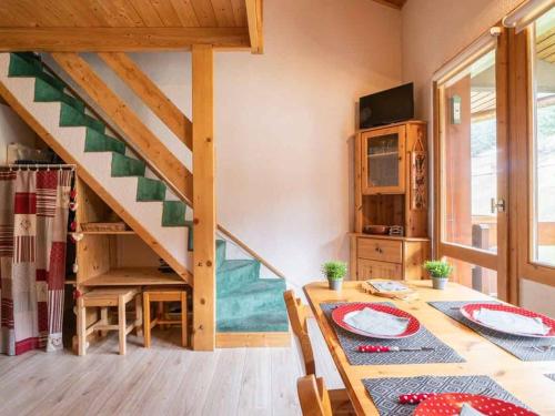 une salle à manger avec une table et un escalier dans l'établissement Duplex cosy 3 pièces avec mezzanine, 2 salles de bain, balcon et casier à skis à Valmorel - FR-1-291-1008, à Valmorel