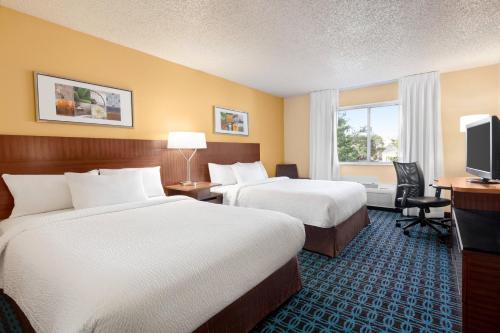 a hotel room with two beds and a television at Fairfield Inn Roseville in Roseville