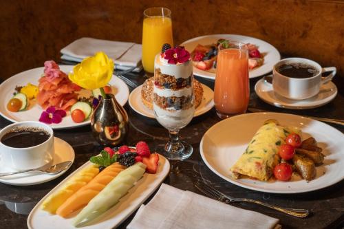 a table topped with plates of food and drinks at The Ritz-Carlton New York, Central Park in New York
