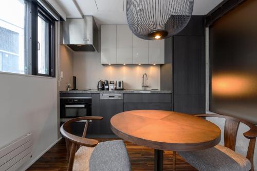 una piccola cucina con tavolo e sedie in legno di Hinzan a Kutchan