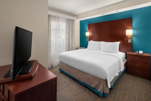 a hotel room with a bed and a flat screen tv at Residence Inn by Marriott Portland Airport at Cascade Station in Portland