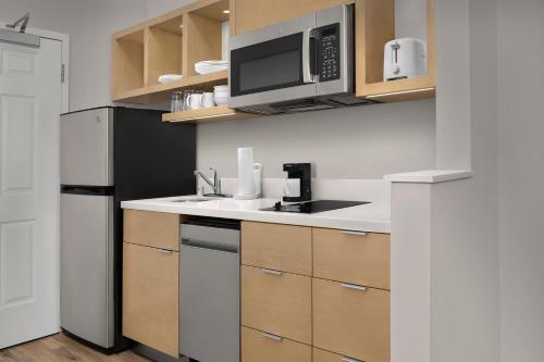 a kitchen with a black refrigerator and a microwave at TownePlace Suites Sacramento Cal Expo in Sacramento