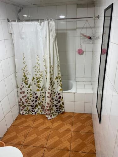 a shower in a bathroom with a shower curtain at Alojamiento Económico in Curicó