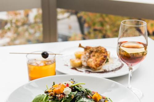 a table with two plates of food and a glass of wine at Sheraton Vancouver Wall Centre in Vancouver