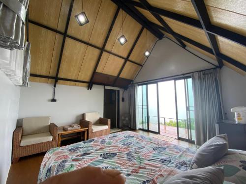 a bedroom with a large bed and a large window at ahpokafei อาโพดอยผาหมี in Ban Pha Mi