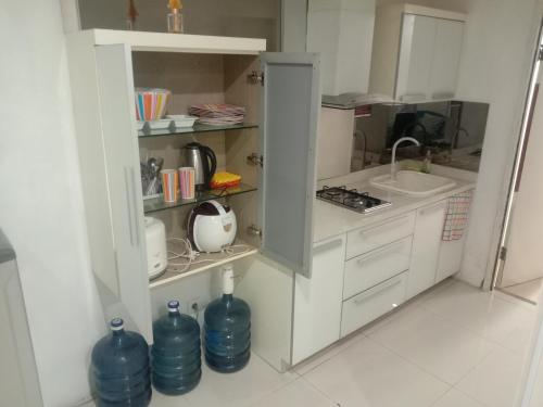 a kitchen with white cabinets and a sink at Apartment Thamrin City 1 Bedroom near Tanah Abang in Jakarta