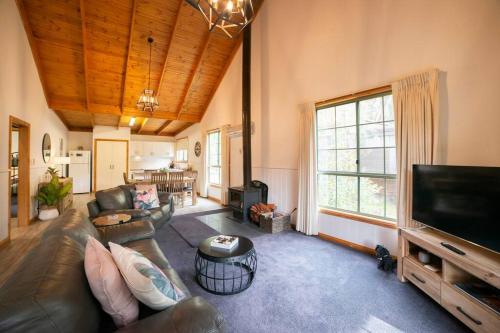 a living room with a couch and a flat screen tv at Country Lane Cottage in Halls Gap