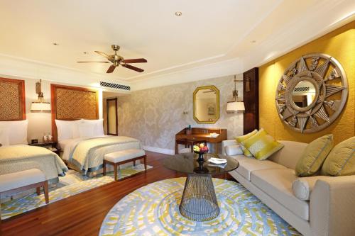 a hotel room with a couch and two beds at InterContinental Bali Resort, an IHG Hotel in Jimbaran