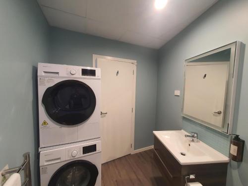 a bathroom with a washing machine and a sink at La Quinta by Wyndham Parnell Auckland in Auckland