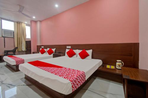 2 camas en una habitación con almohadas rojas y blancas en Hotel Rameshwaram, en Jaipur