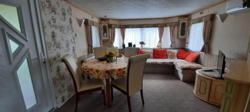 un soggiorno con un tavolo e un divano di Ezüst fenyő vendégház a Borzont