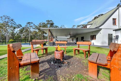 a group of picnic tables and a fire in front of a building at Kitchener Country Estate with Pool Hot Tub on private acres that sleeps up to 18 in Kitchener
